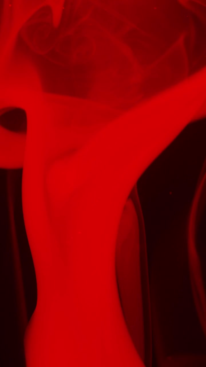 Fumo rosso atmosferico e particelle su sfondo nero