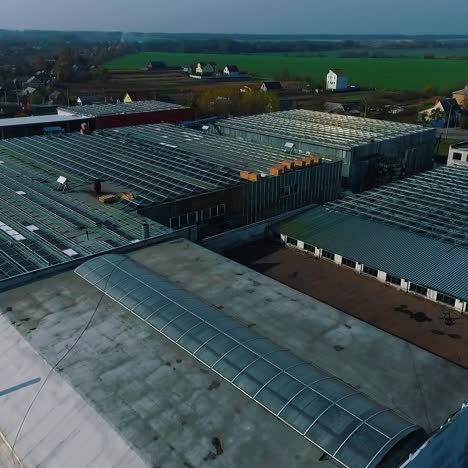 solar panels installation on roof of facrory by installers. aerial top down view of just finished modern neighborhood apartment building with solar panels
