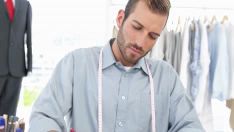 un guapo diseñador de moda dibujando en su escritorio