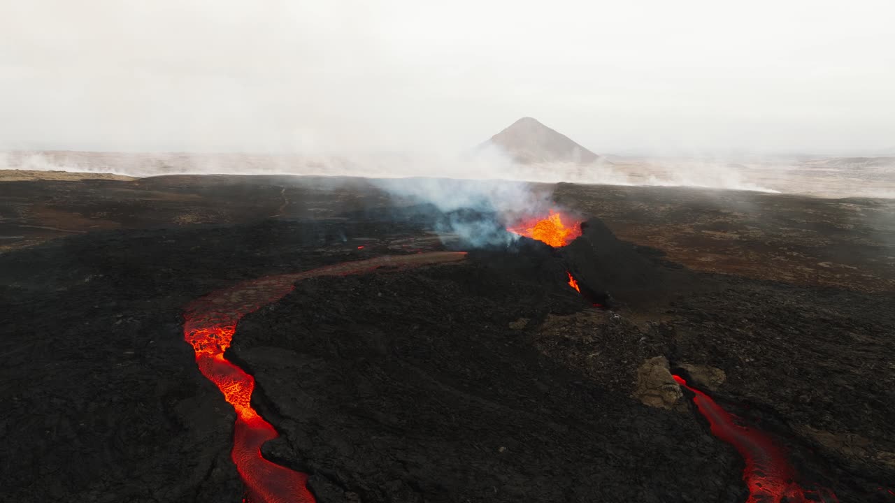 Aerial panoramic landscape view over the volcano erupting at Litli-Hrutur, Iceland, with lava and smoke coming up