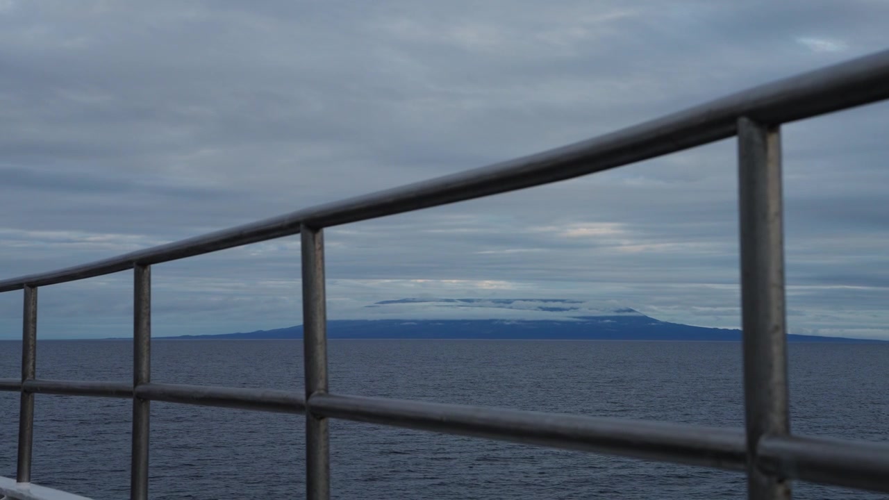 Een vulkaan is te zien vanaf het dek op een stemmige Galapagos-avond (4K)