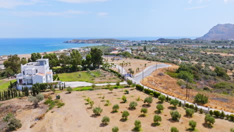 aerial view over villas on a hill, approaching kolymbia town in rhodes, greece