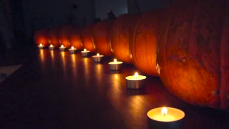 pumpkins and candles on a table at night