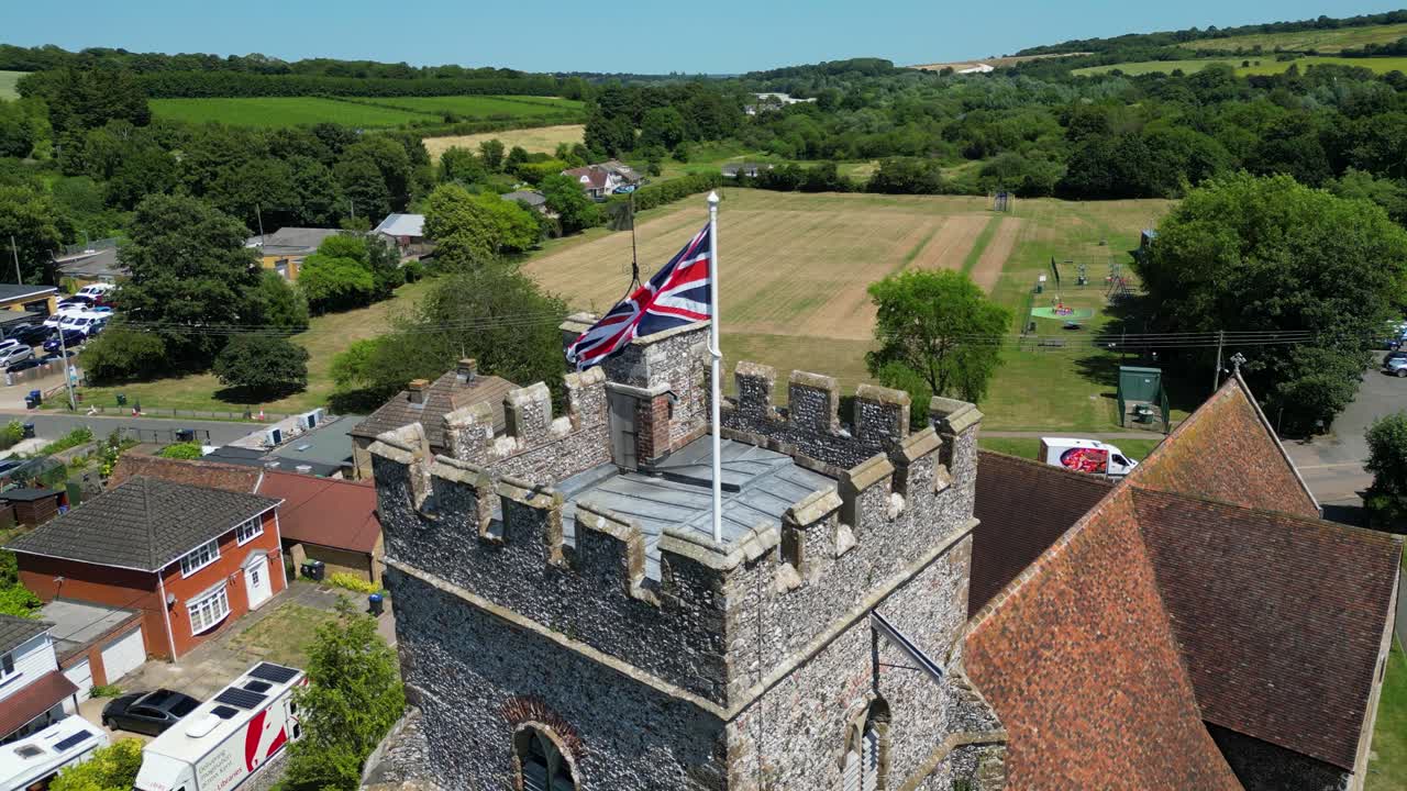 A slow boom-shot of a union flag flying from the tower of St Mary's church in Chartham