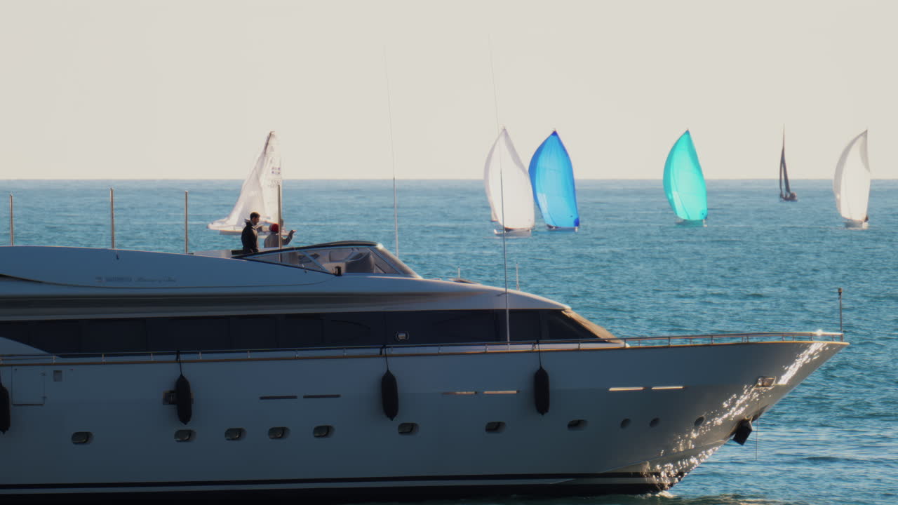 Nice, France - February 10, 2025: A boat with the flag of Monaco moving on the sea with small sailboats on the background