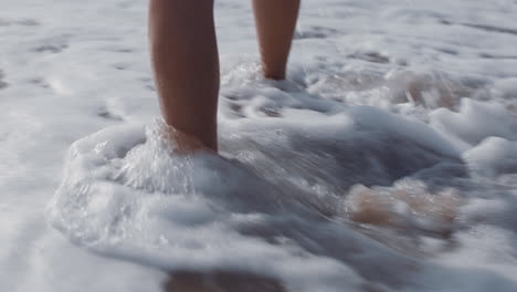 close up woman feet walking barefoot on beach enjoying waves splashing gently female tourist on summer vacation