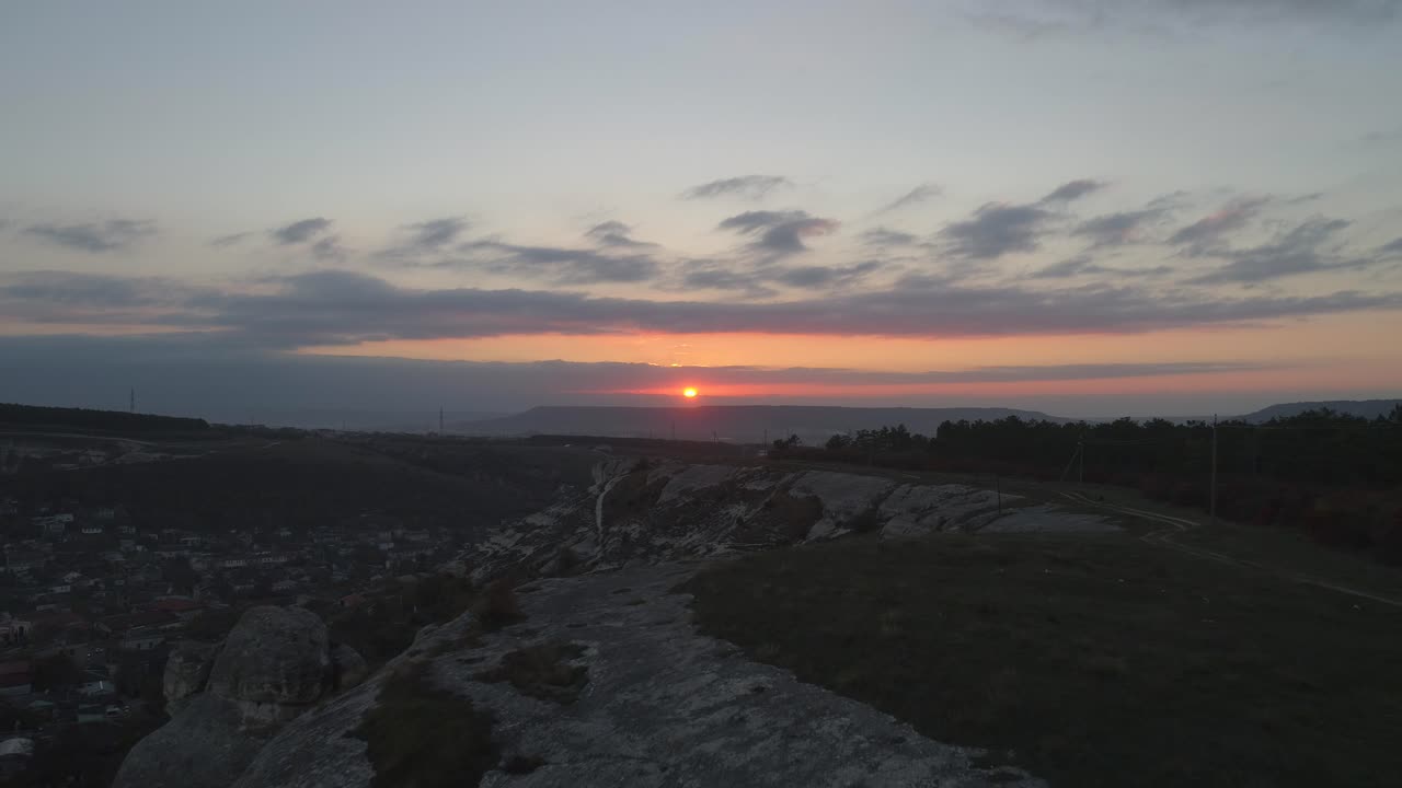 puesta de sol sobre la cordillera con una vista de la ciudad