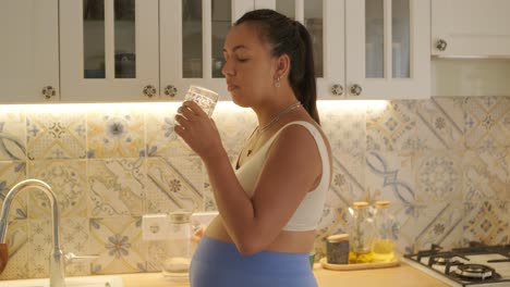 a pregnant woman enjoying her daily routine at home, relaxing in the living room and eating in the kitchen. the scene highlights comfort, maternity, and moments of self-care in a cozy setting