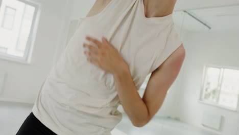 un joven bailarín realiza movimientos de danza contemporánea en un entorno de estudio