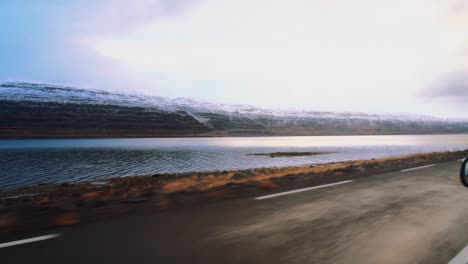 view of a big river and snowed mountains in iceland while driving