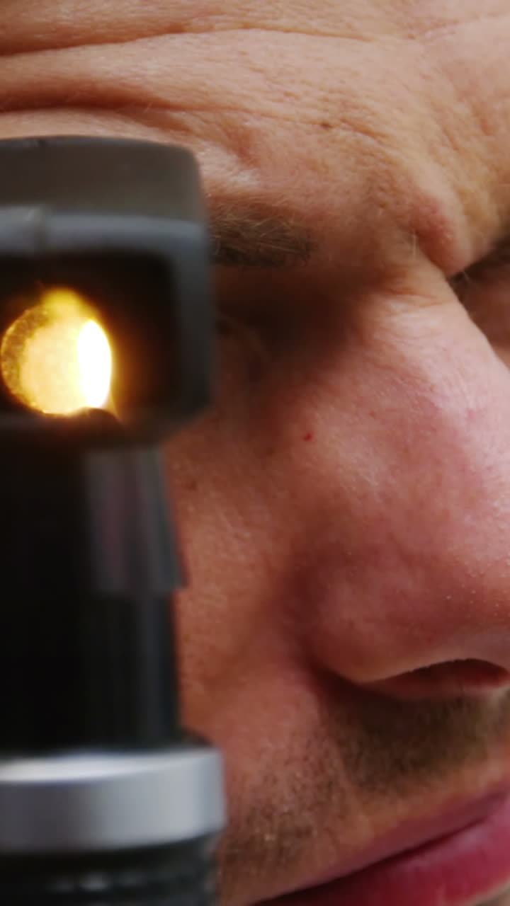 primer plano del optometrista mirando a través del oftalmoscopio