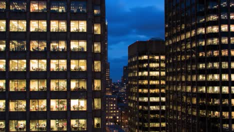 A Dusk to Night Transition Overlook of a City Skyline with Illuminated Office Buildings Highlighting the Busy Work Environment under a Twilight Sky