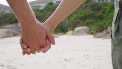 holding hands, love and couple walking in a beach