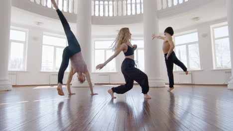 tre ballerini professionisti di danza contemporanea che si allenano in studio 3