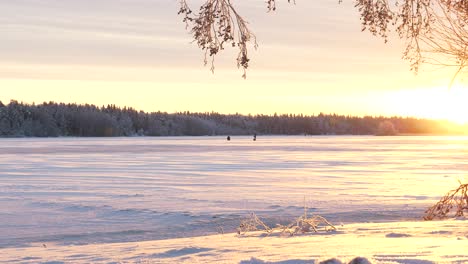 Hermosa-Puesta-De-Sol-Que-Ilumina-El-Paisaje-Del-Lago-De-Invierno-Y-Los-Pacientes-Pescadores-De-Hielo