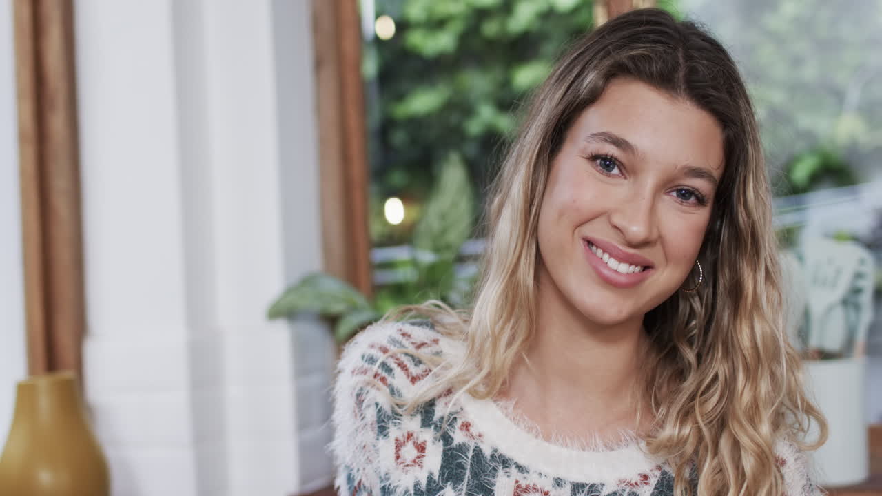 retrato de una feliz mujer biracial con cabello rubio en casa, cámara lenta, espacio de copia
