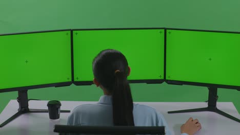 트리플 모니터 설정에서 일하는 여성