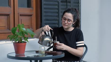 Reveladora-Foto-De-Una-Hermosa-Morena-Tirando-Agua-Y-Bebiendo-Un-Mate,-Una-Bebida-De-Argentina-Y-Uruguay