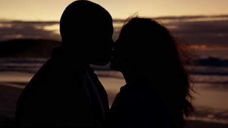 Kiss,-silhouette-and-sunset-with-couple-at-beach