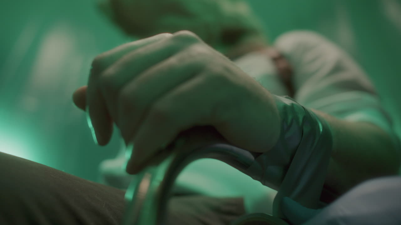 Mani guantate di un serial killer che lega un ostaggio a una sedia con nastro adesivo
