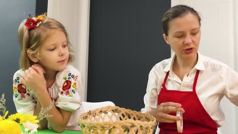 mother and daughter making a decorative basket