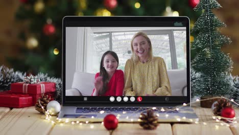 Feliz-Madre-E-Hija-En-Videollamada-En-Computadora-Portátil,-Con-Adornos-Navideños-Y-árbol