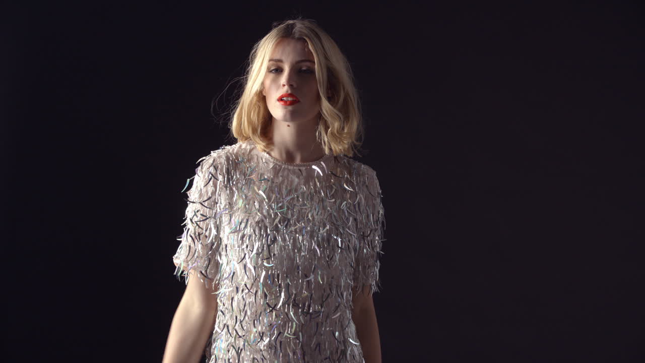 반 ⁇ 이는 드레스를 입은 여자가 손을  ⁇ 고 돌아갑니다.