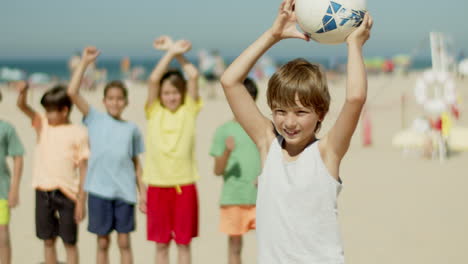 Medium-shot-of-cute-blonde-Caucasian-boy-lifting-soccer-ball-up