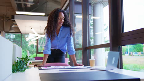 Portrait-Of-Businesswoman-Standing-At-Desk-In-Office-Approving-Or-Checking-Proofs-Or-Design-Layouts