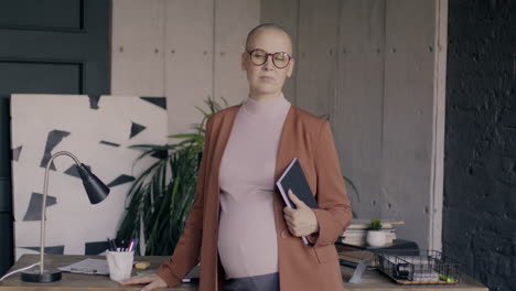 confident pregnant businesswoman in office
