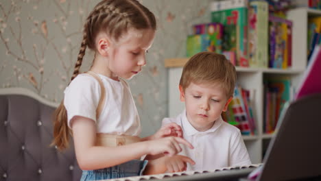 la hermana le explica los acordes al hermano en el piano eléctrico en casa