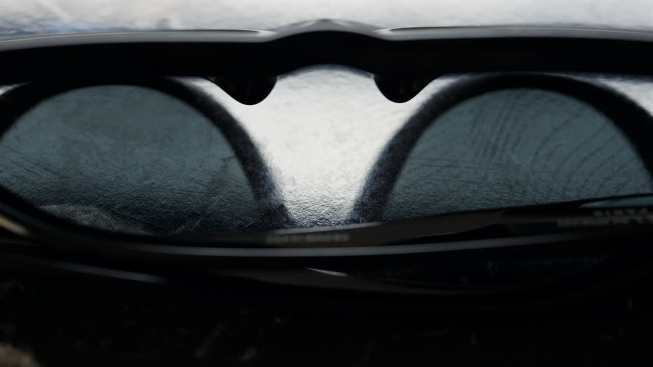 Close up of a black pair of sunglasses on a black surface