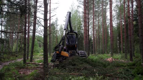 Aerial-sideways-shot-of-Scandinavian-finnish-forest-and-forestry-machine-Ponsse-Scorpion-harvester-filmed-with-DJI-Air-2s