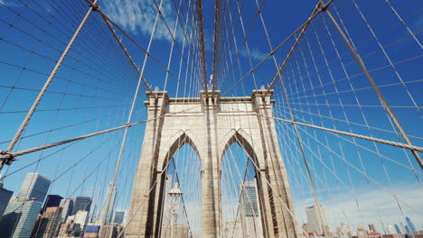 brooklyn bridge and the outline of the skyscrapers of manhattan behind him