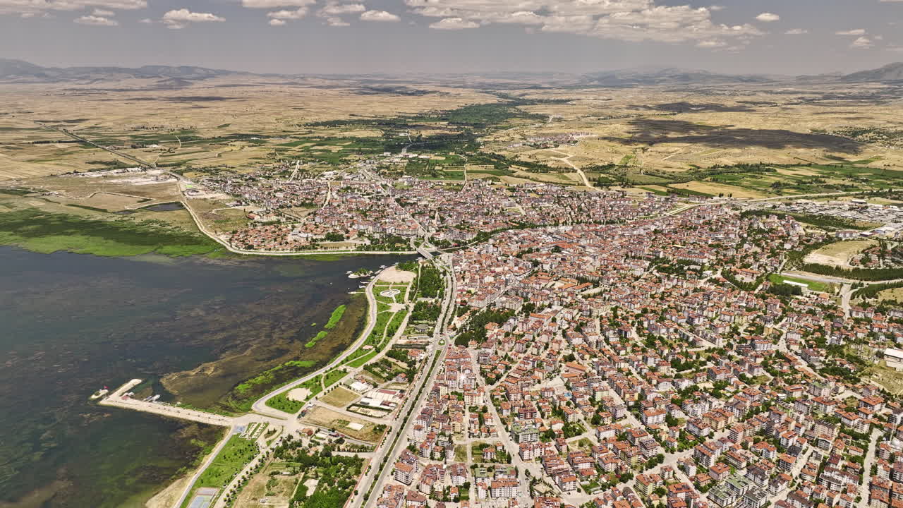 beyşehir turkey 공중 v3 시네마틱 하이 앵글 패닝 뷰, 무인 항공기 비행 호숫가 마을은 산경관이 있는 민물 호수의 아름다운 풍경을 캡처합니다 - mavic 3 cine으로 촬영 - 2022년 7월