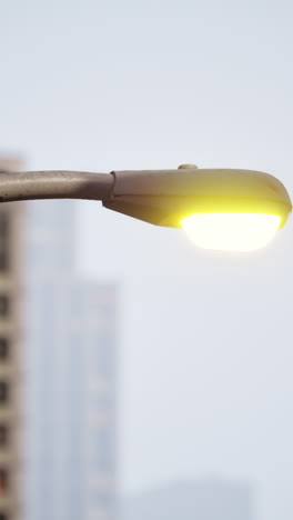 a street light illuminates the foggy city street at night.