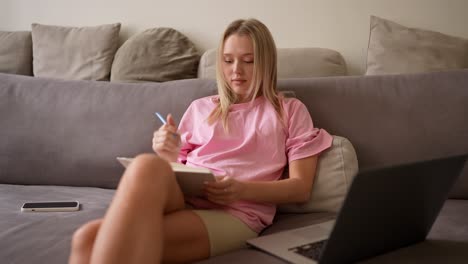 woman studying on a sofa at home