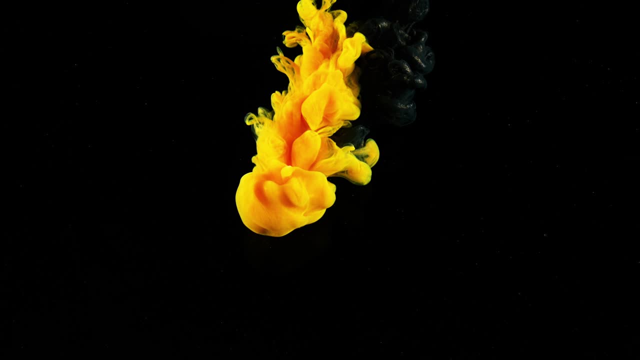 медленное движение смешивания цветов в воде. запасные кадры. желтая и черная чернила медленно, как дым в воде на черном фоне. красивая чернила в воде для заставки фона