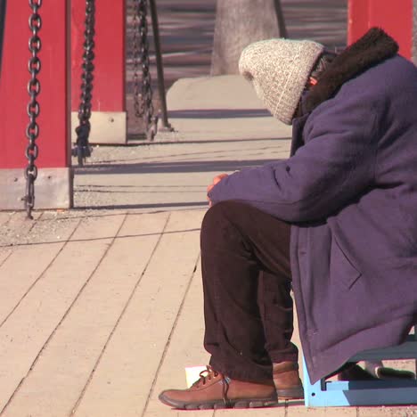 a homeless person sits on a bridge in norway 1