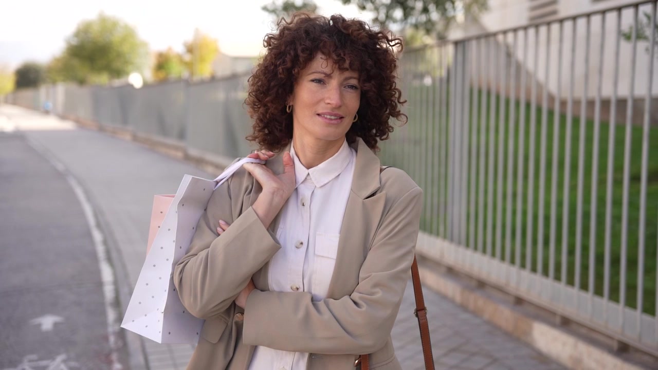 Uma mulher com cabelo encaracolado está fazendo compras em um ambiente urbano vibrante.