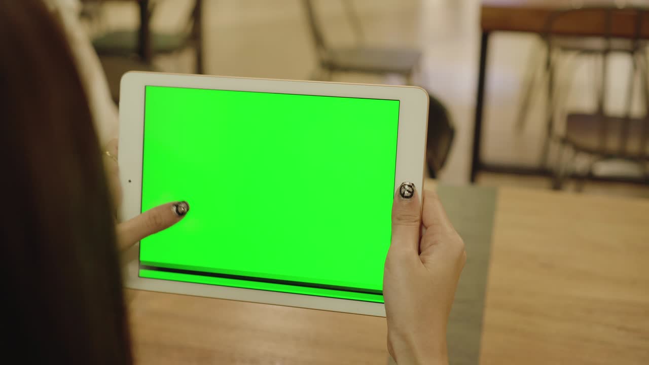 빈 녹색 화면 디스플레이와 손가락이 스크린을 만지고 스와이프하는 태블릿을 들고 있는 여성.