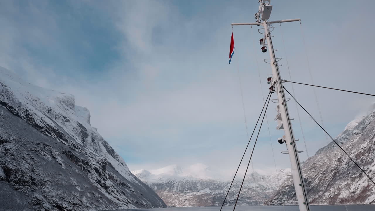 노르웨이의 geirangerfjord에서 눈 인 산과 매혹적인 피오르드 전망을 가진 겨울 페리 보트 타기의 느린 동작