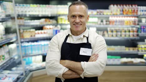 portrait of a middle-aged shot worker in and apron. the man puts his hands on his chest. the concept of working in a grocery