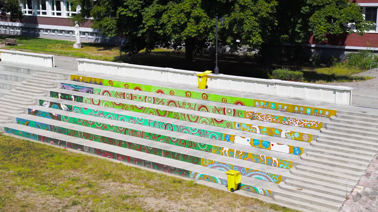 Colorfully painted stairs and three yellow trashbin in Hungary.