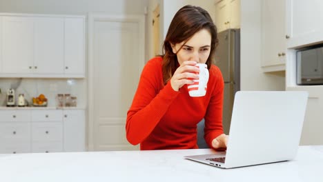 Woman-using-laptop-in-kitchen-4k