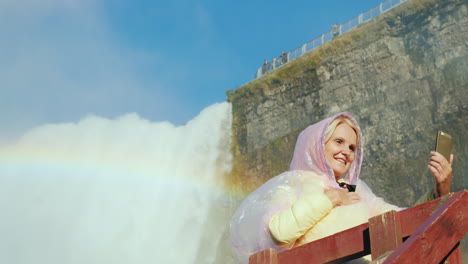 mujer se toma selfie junto a las cataratas del niágara