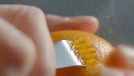 a woman uses a zester on an orange