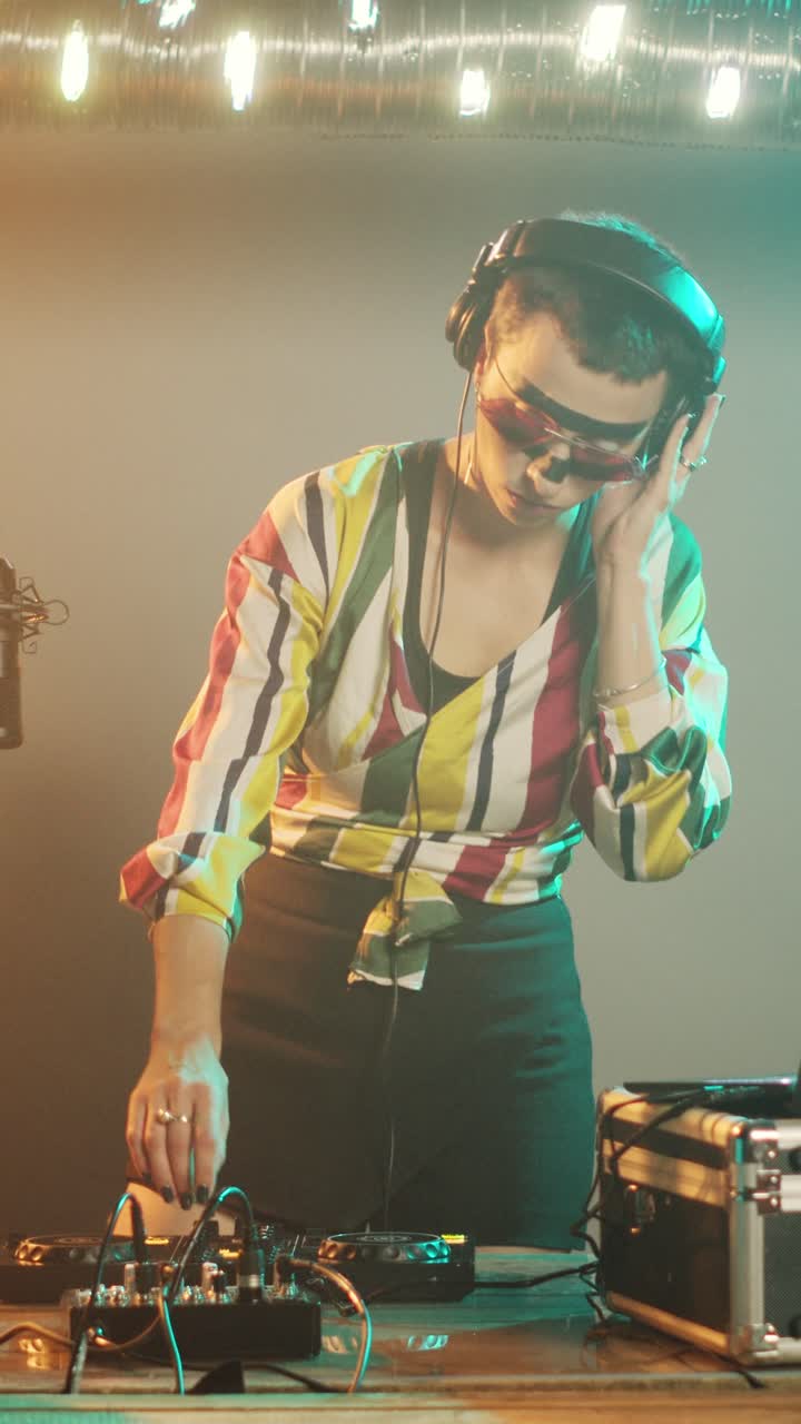 Video verticale: DJ donna che produce musica techno al mixer