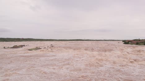 aldea, árboles y pequeñas colinas sumergidas en inundaciones debido a las fuertes lluvias que causan un fuerte flujo de agua del embalse en el norte de karnataka, india