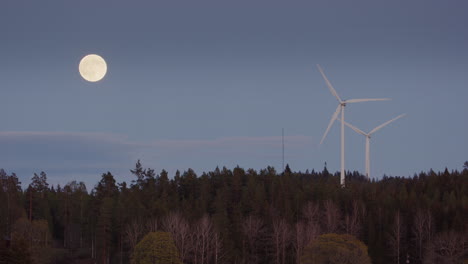 Luna-Llena,-Crepúsculo:-Las-Turbinas-Eólicas-Giran-Rápido-Junto-A-Una-Luna-Llena-En-Ascenso